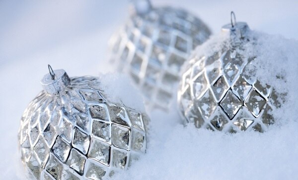 three stunning silver ornaments sitting in a bed of snow three stunning silver ornaments sitting in a bed of snow