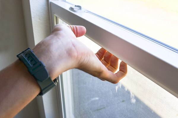 A hand, trying desperately to claw open a stuck sliding window