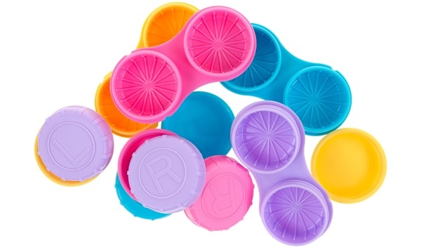 A jumble of several contact lens storage cases with separate covers on a white background