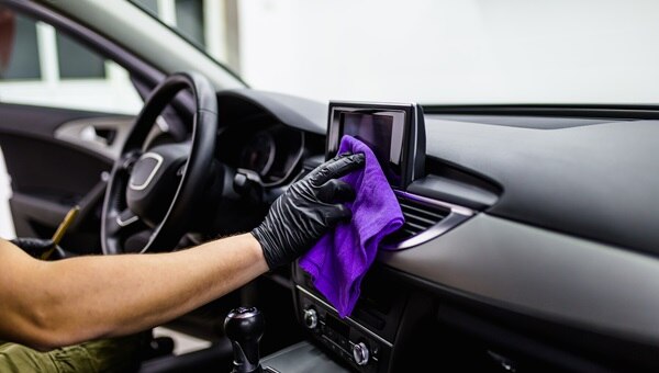 A pair of hands spring cleaning a car interior