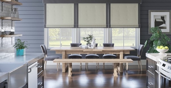 Outside mount Roman shades featured in a stylish kitchen dining room.