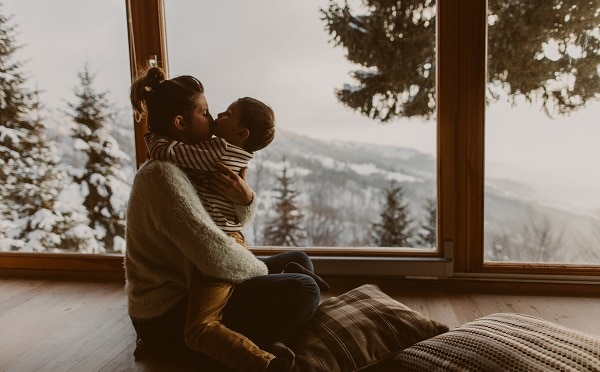 A mother and her child embrace in a minimalist living room that perfectly represents hygge