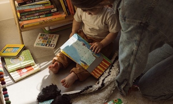 a mother and her son reading books in a playroom, barefoot and ready to learn